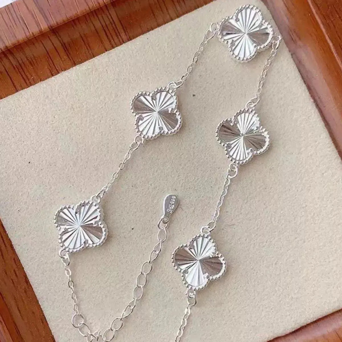 Close-up of four leaf clover charm on silver bracelet