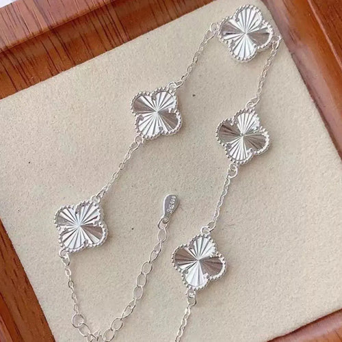 Close-up of four leaf clover charm on silver bracelet