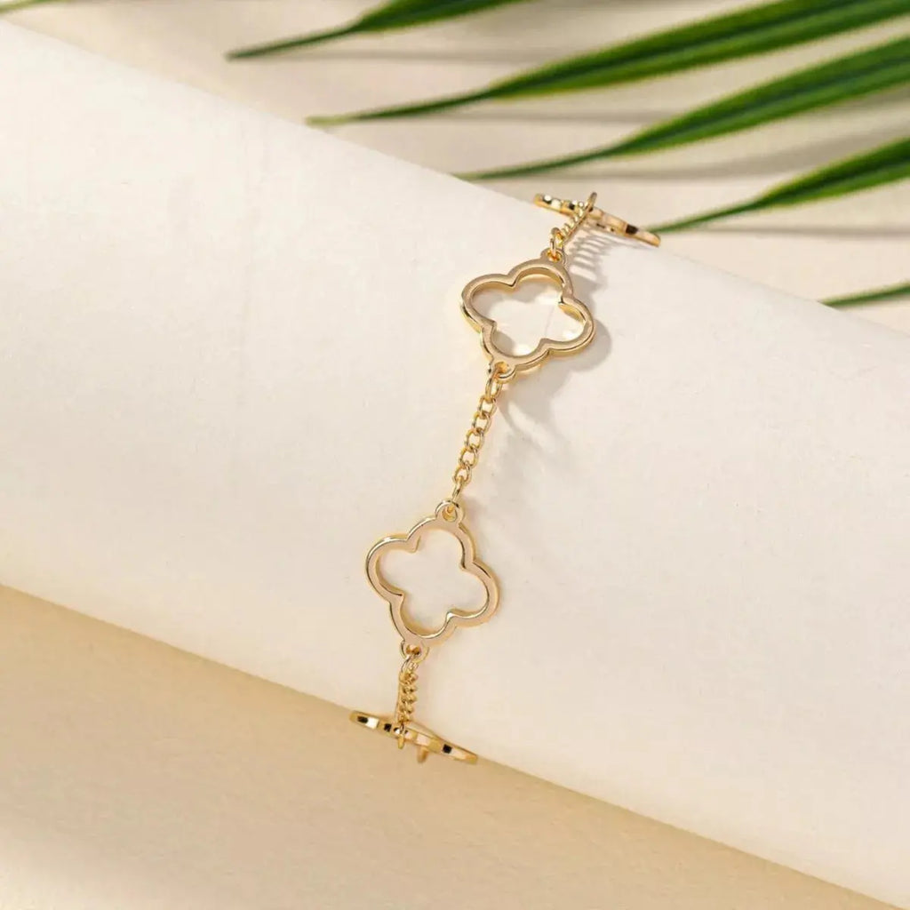 Close-up of clover charm on gold bracelet