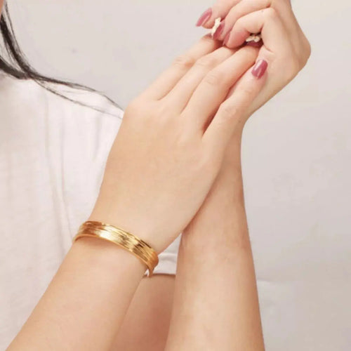 Close-up of copper detail on gold open bracelet
