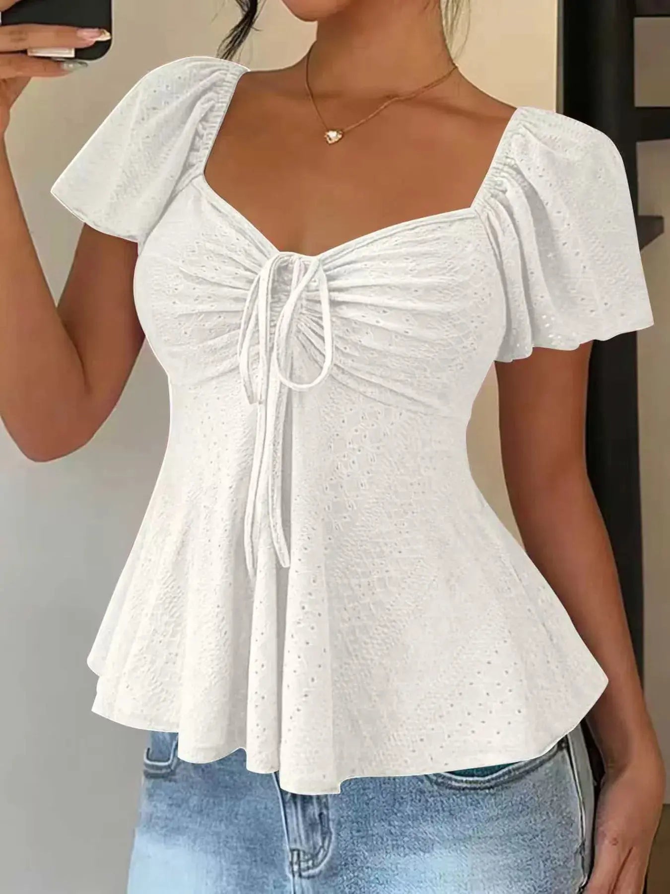 Close-up of eyelet detailing on sweetheart neck flutter sleeve top