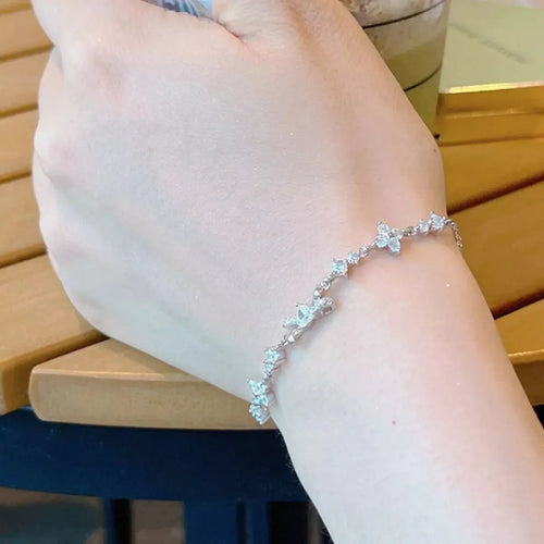 Close-up of bow charm on silver chain bracelet