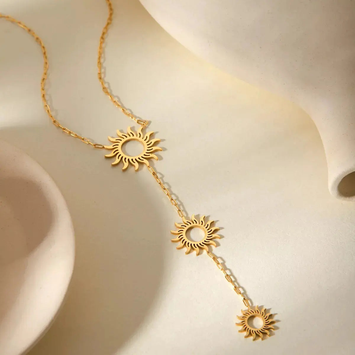 Close-up of sun pendant detail on gold necklace