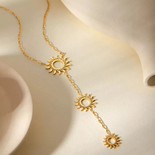 Close-up of sun pendant detail on gold necklace