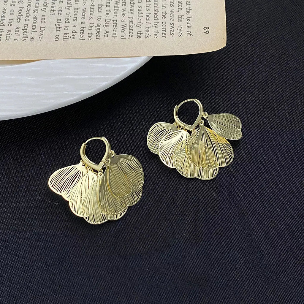 Close-up of textured leaf detail on gold earrings