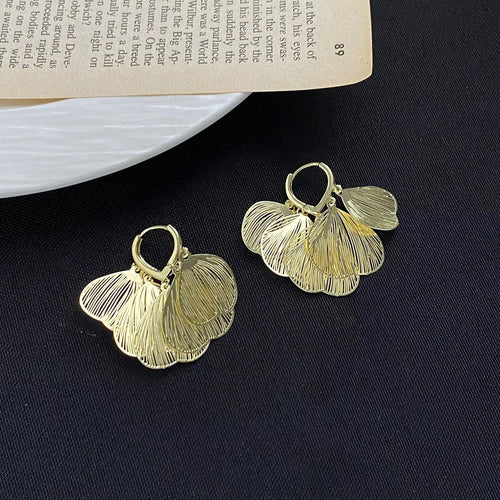Close-up of textured leaf detail on gold earrings