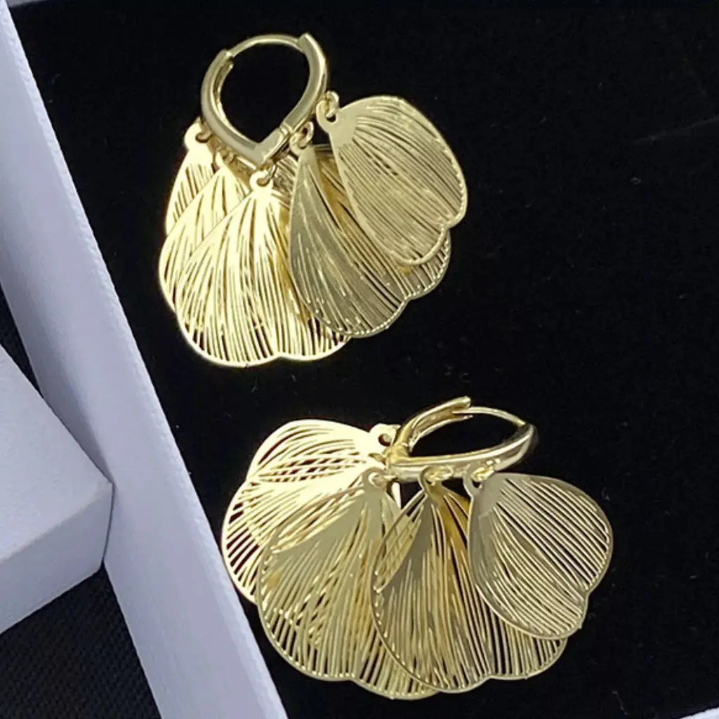 Woman wearing gold leaf drop earrings