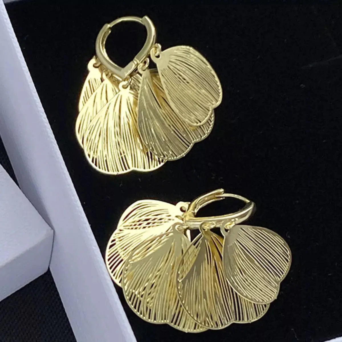 Woman wearing gold leaf drop earrings