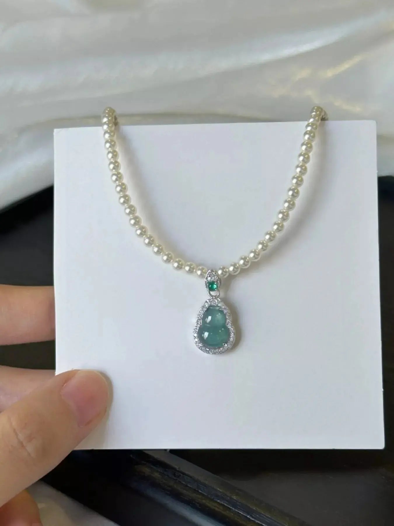 Woman wearing gourd pendant pearl necklace