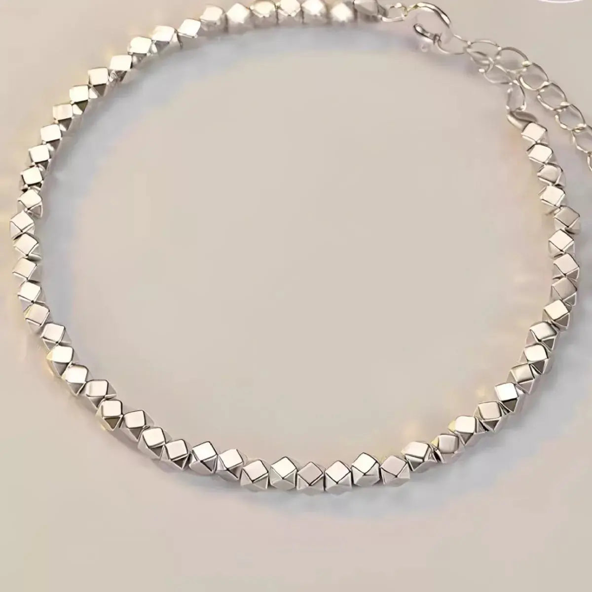 Close-up of geometric chain link detail on silver bracelet