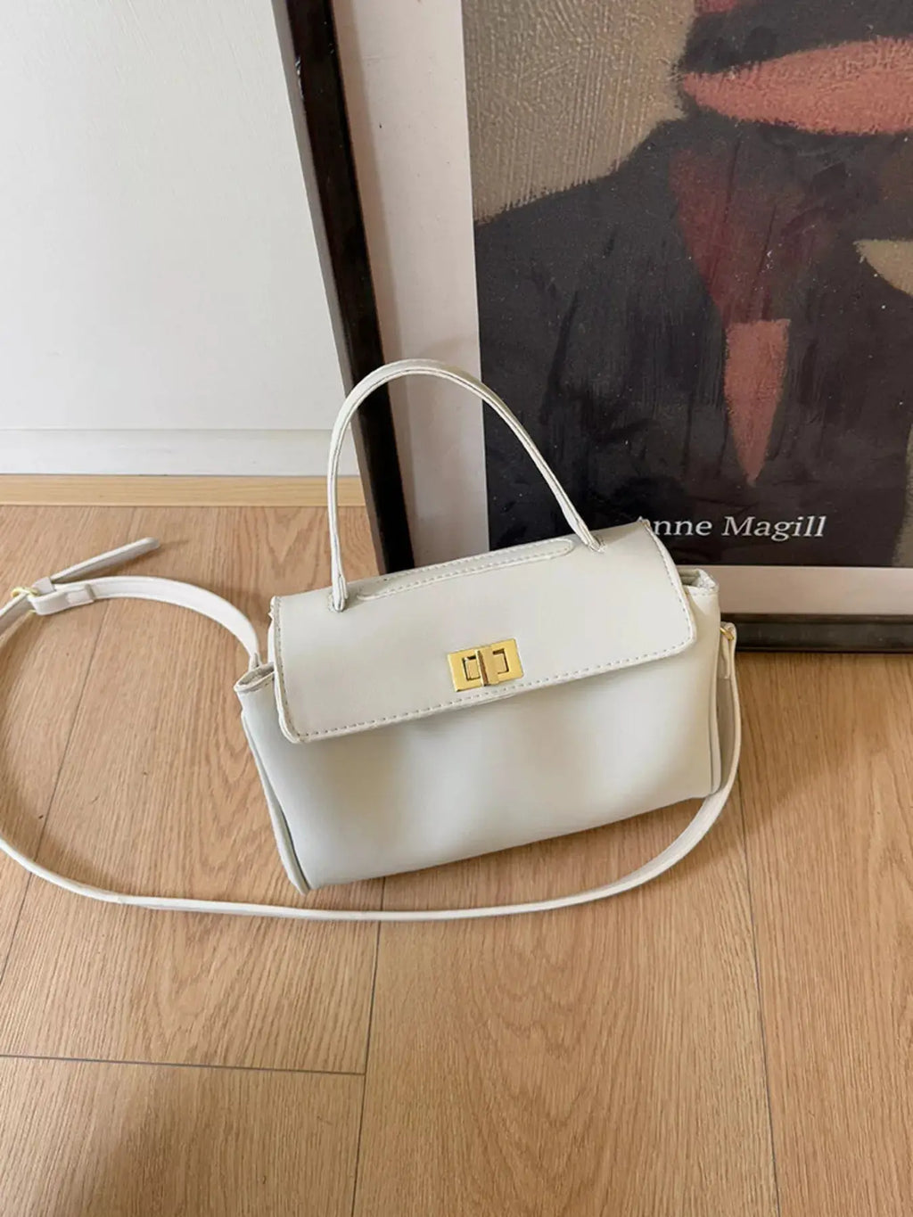 Gold twist-lock structured crossbody bag hardware detail
