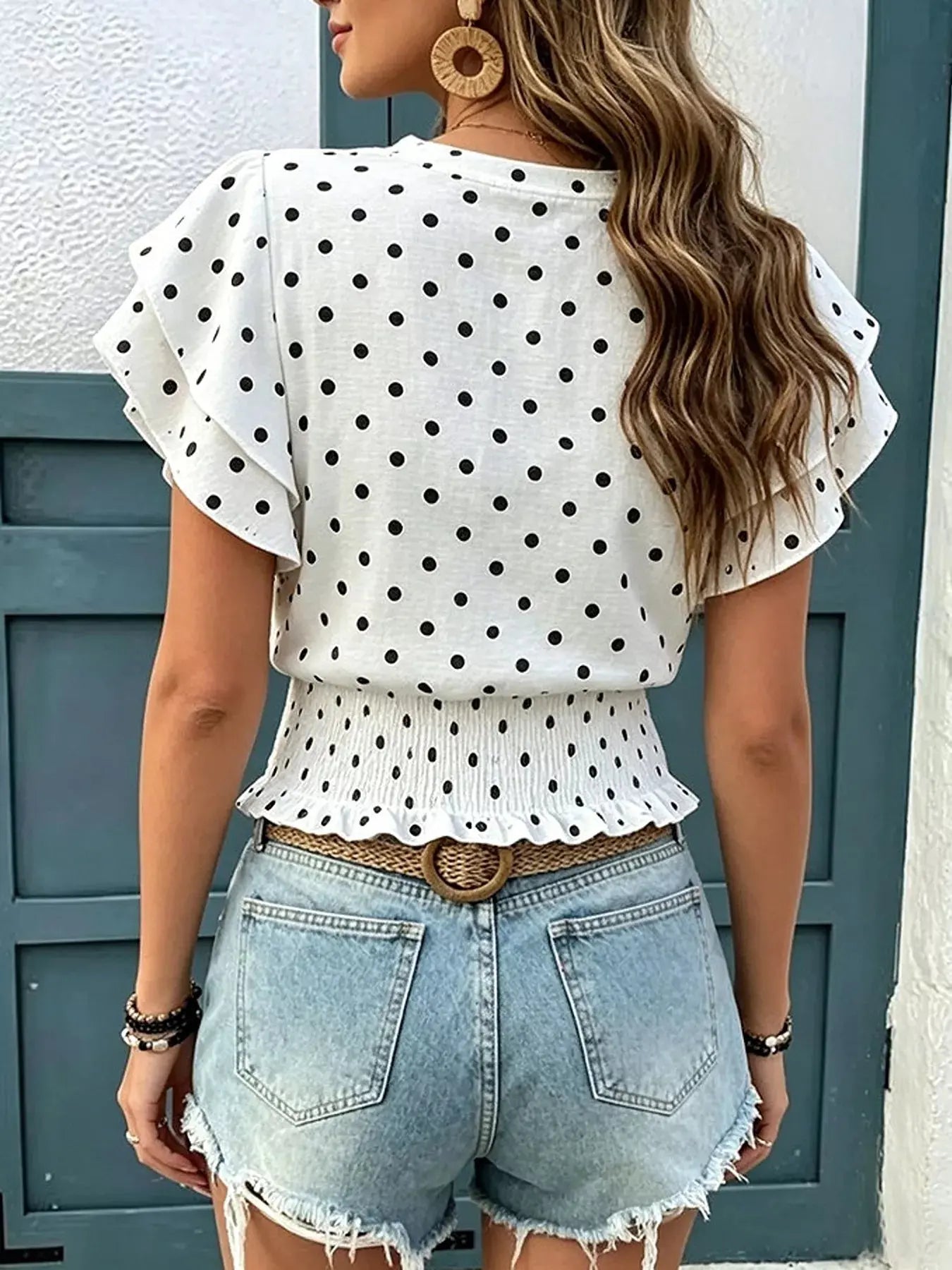 Close-up of ruffled sleeve detail on polka dot blouse