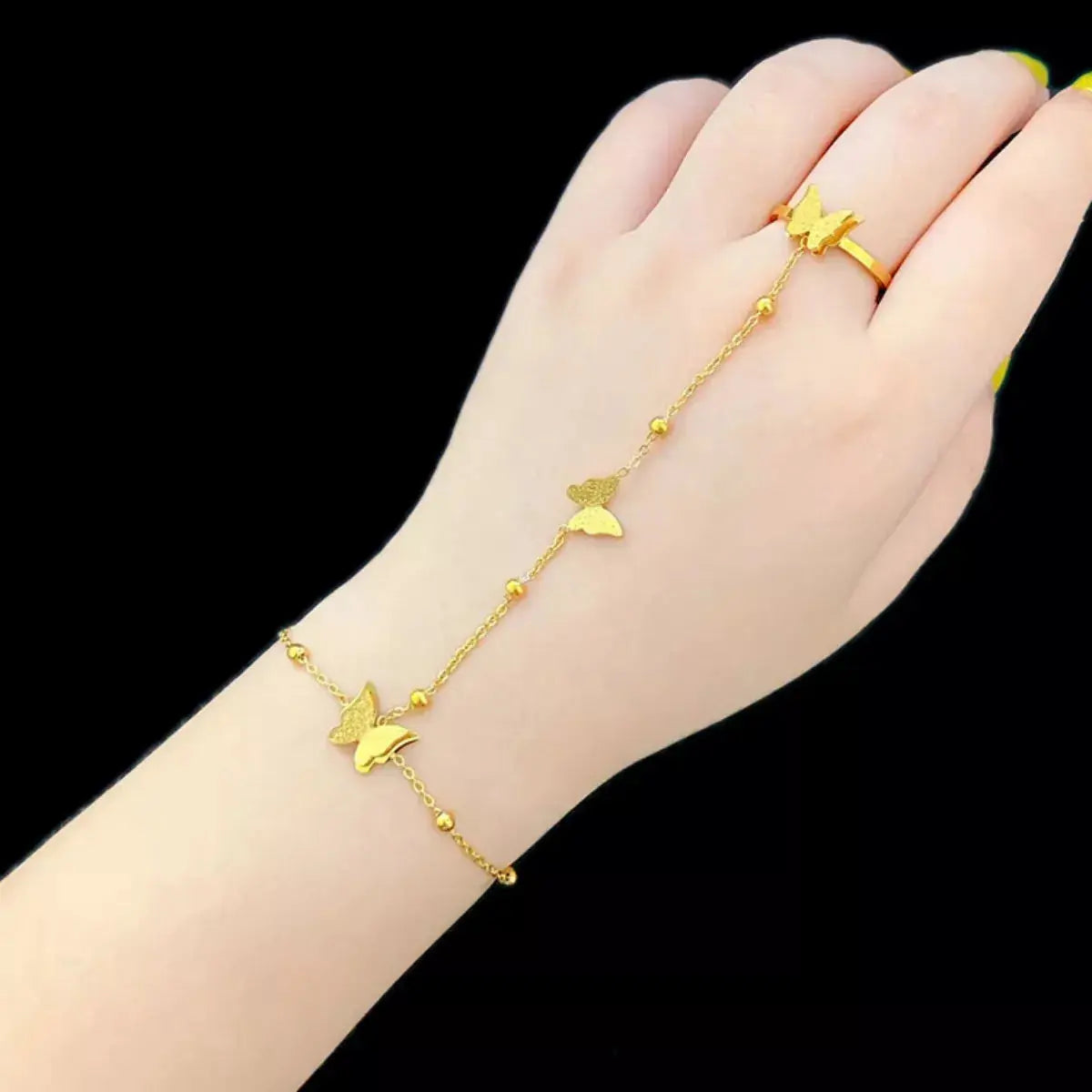 Woman wearing butterfly charm finger bracelet