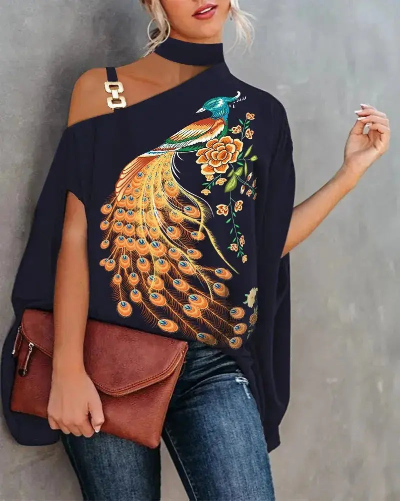 Woman wearing a navy blue off-shoulder top with peacock and floral embroidery, holding a brown leather bag.