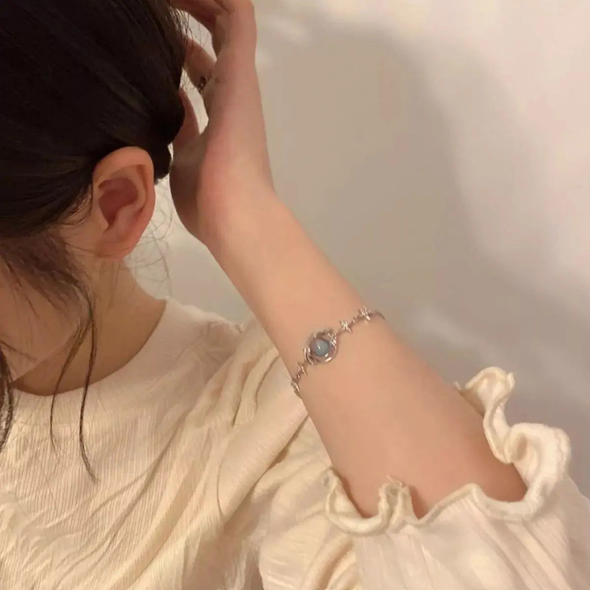 Close-up of planet charm on silver bracelet