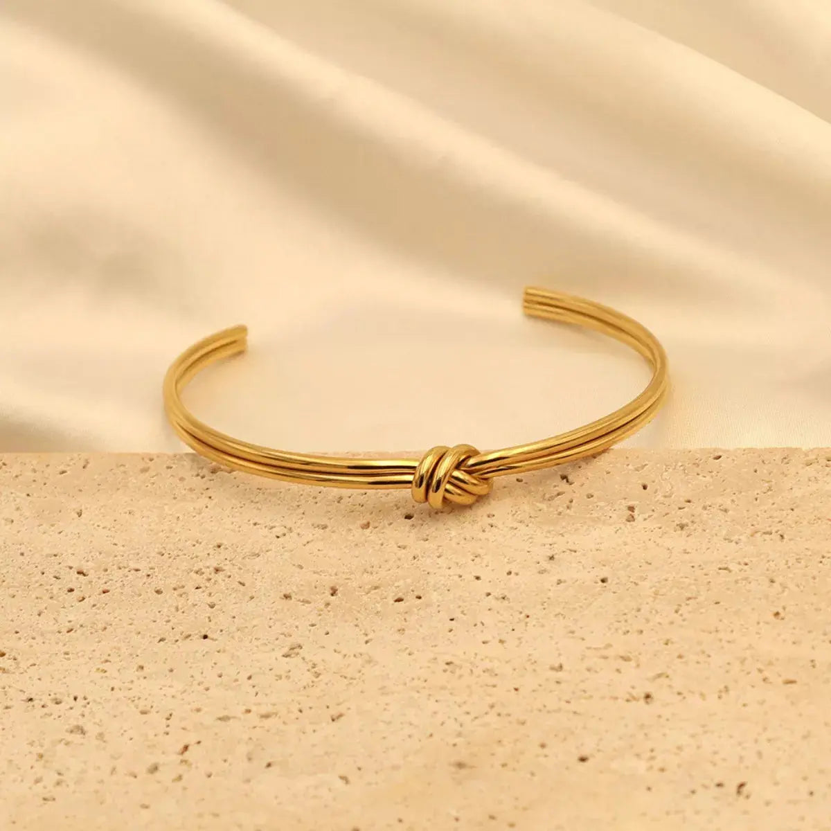 Close-up of knot detail on gold open bracelet