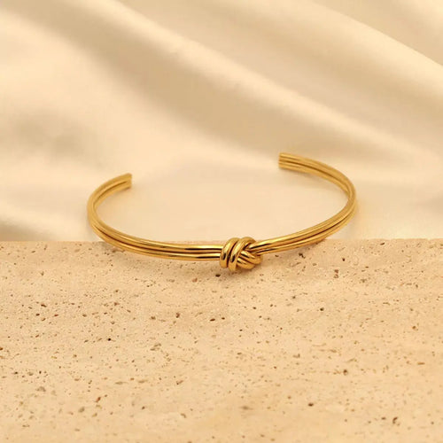 Close-up of knot detail on gold open bracelet