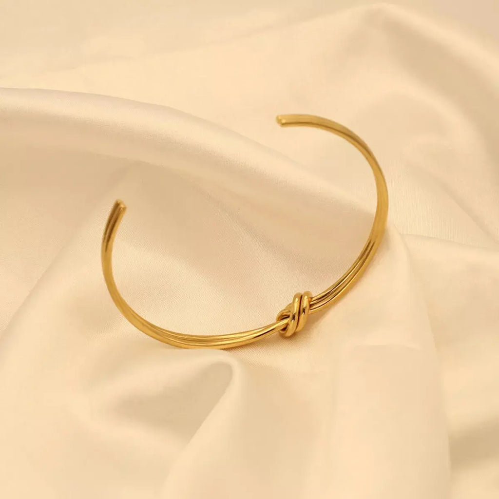 Woman wearing gold knot open bracelet