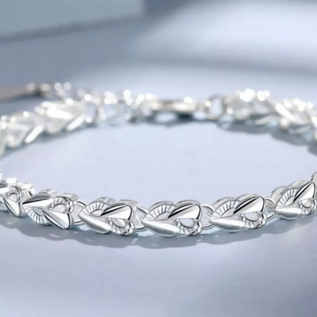 Woman wearing silver heart link bracelet