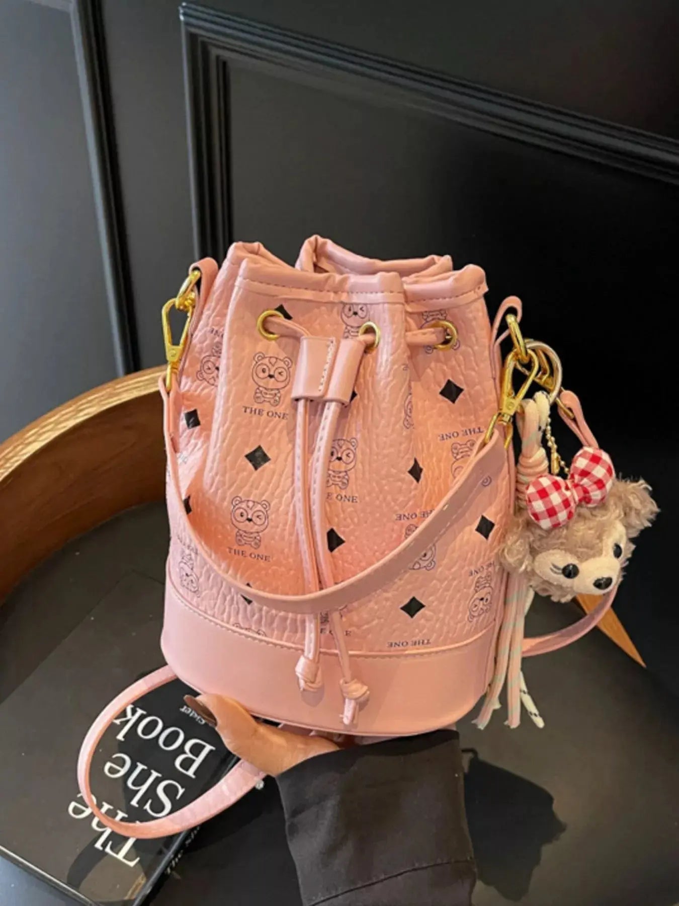 Mini drawstring bucket crossbody bag with charm, front view