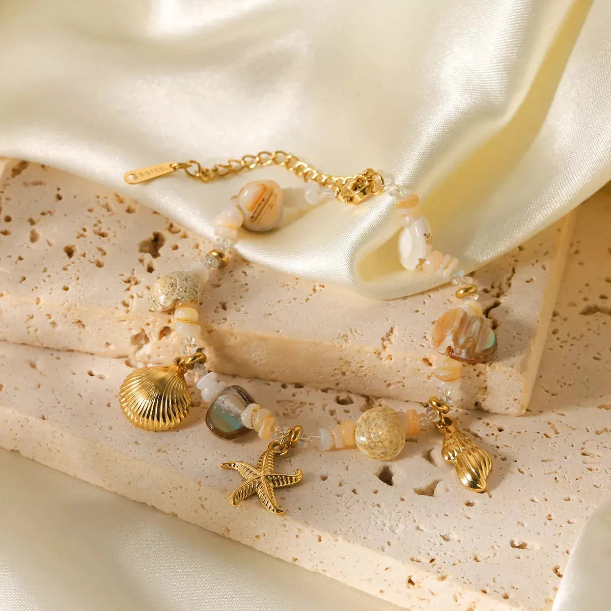 Close-up of shell charm on gold bracelet