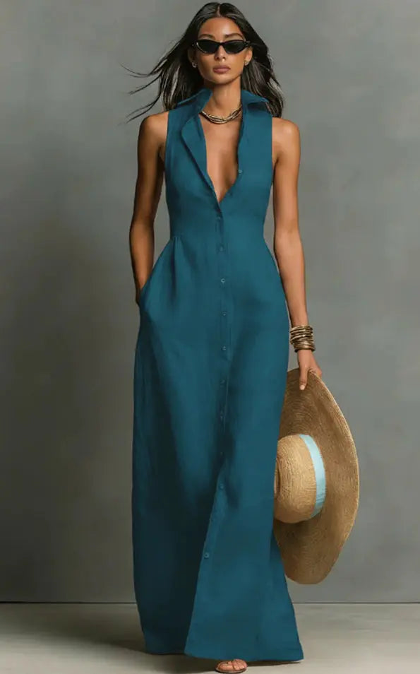Woman in a teal sleeveless dress holding a hat against a gray background