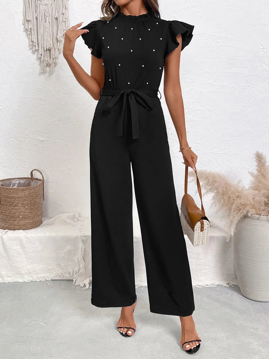 Woman wearing a pearl detail ruffled cap sleeve jumpsuit from Vicsxox
