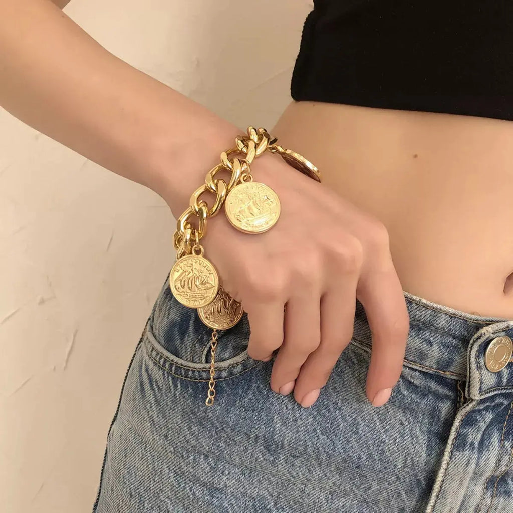 Woman wearing gold coin charm bracelet