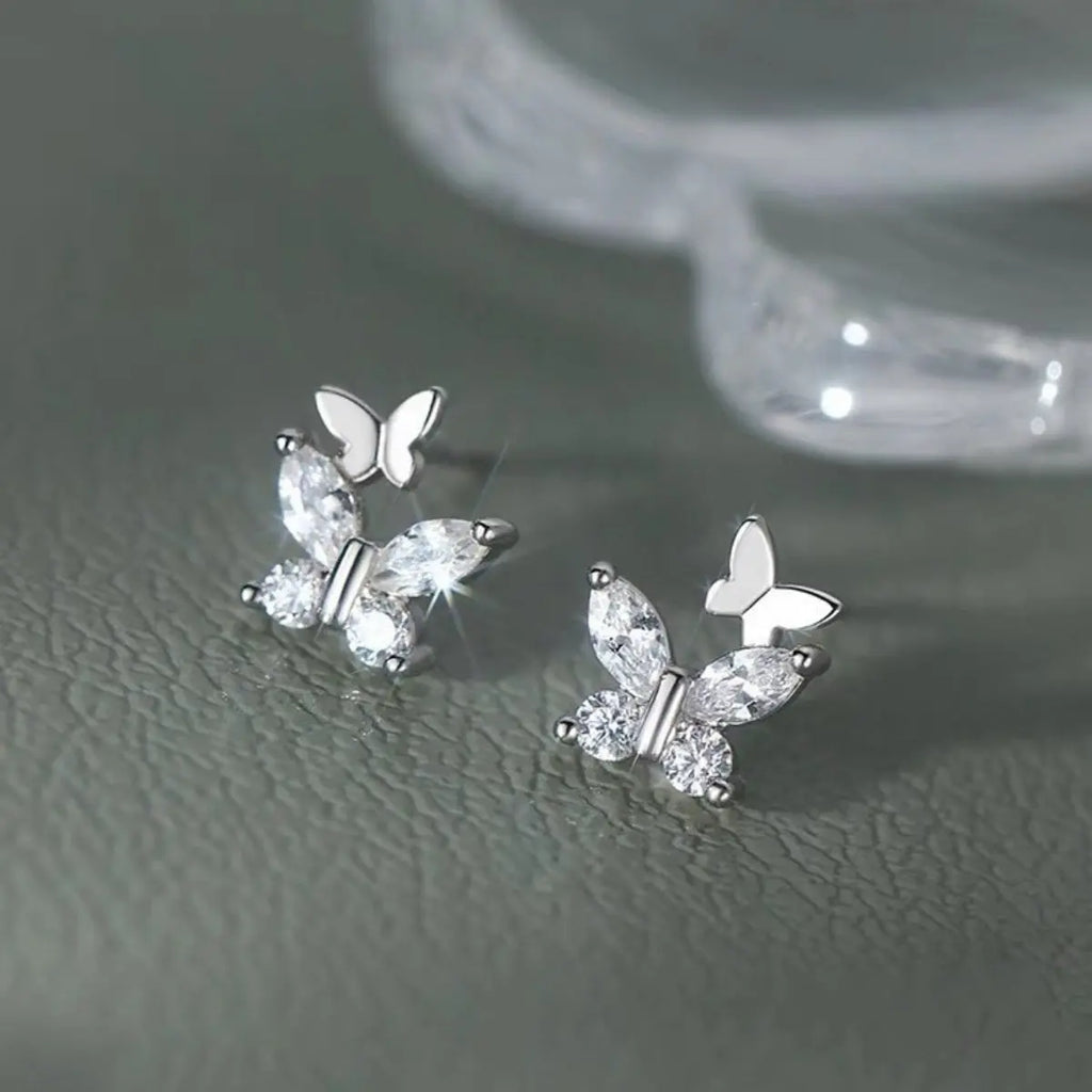 Close-up of butterfly design on silver stud earrings