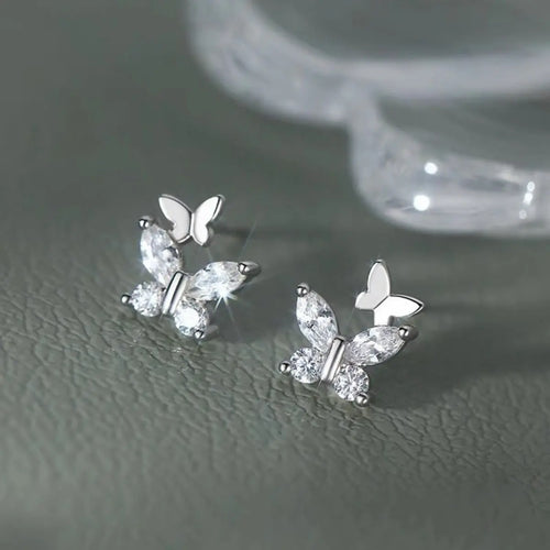 Close-up of butterfly design on silver stud earrings