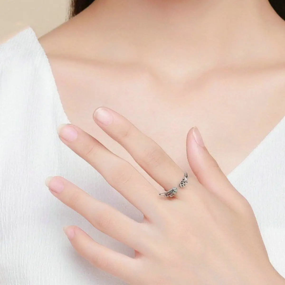 Woman wearing silver angel wing open ring