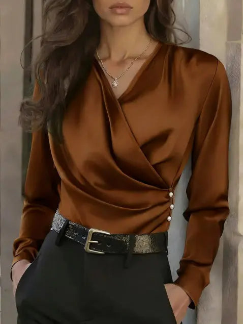 Brown satin blouse with black pants against a neutral background