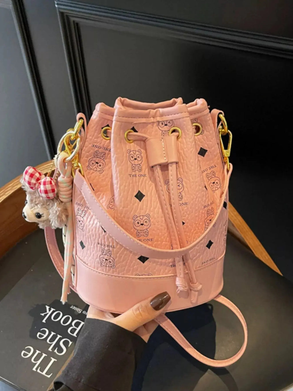 Mini drawstring bucket crossbody bag charm detail
