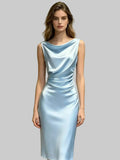 Woman wearing a light blue satin dress against a plain background