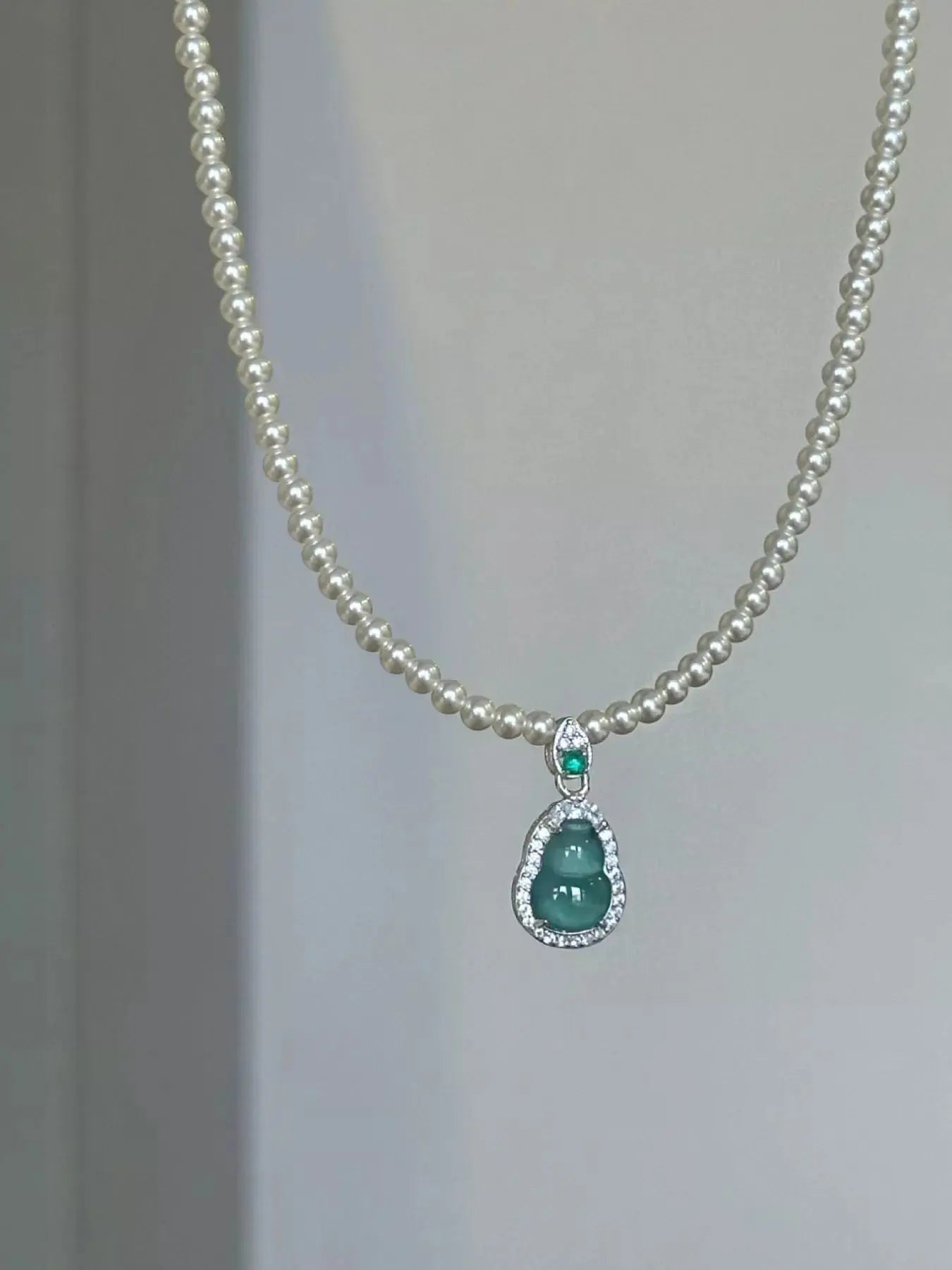 Close-up of gourd pendant with jade and zircon accents