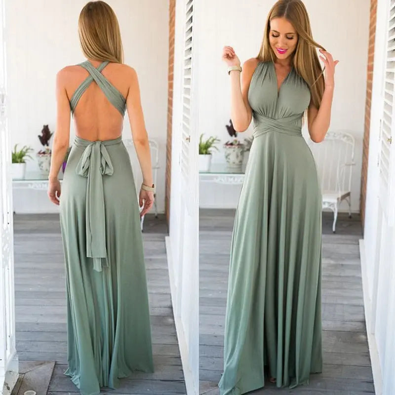 Woman wearing a green maxi dress with a backless design, standing in a bright room.