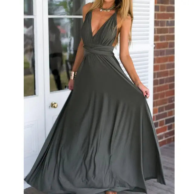 Woman wearing a long dark green dress in front of a door.
