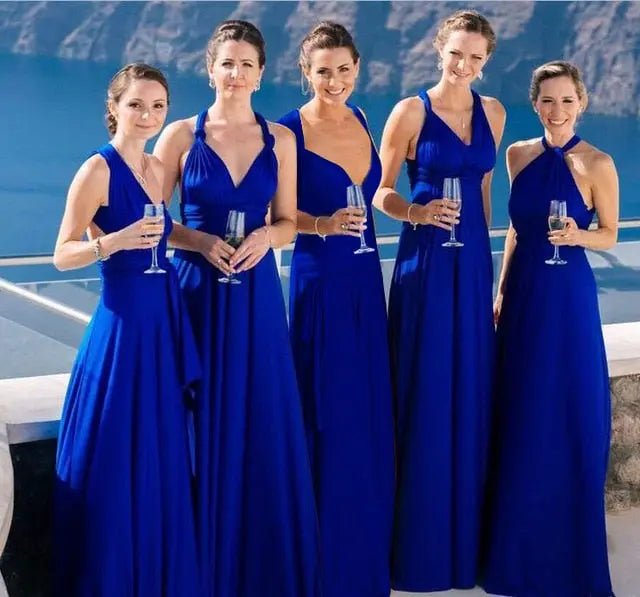 Five women in blue dresses holding glasses by a pool.
