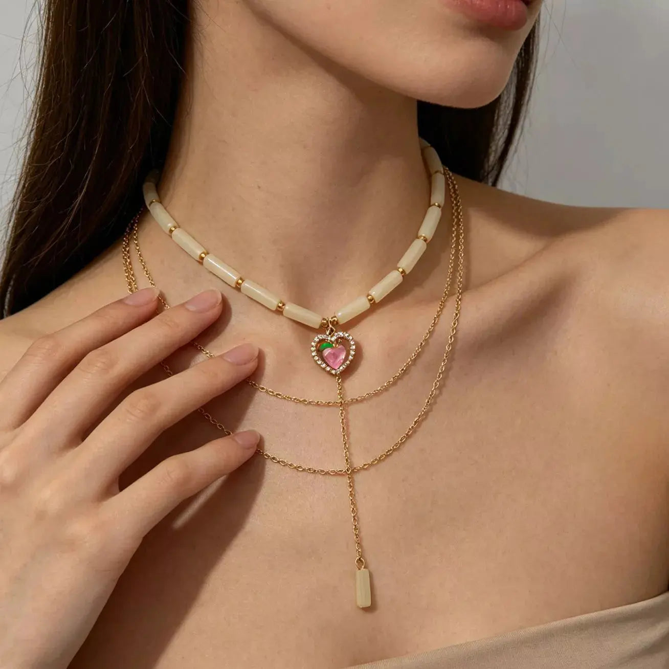 Close-up of jade beads on layered heart necklace