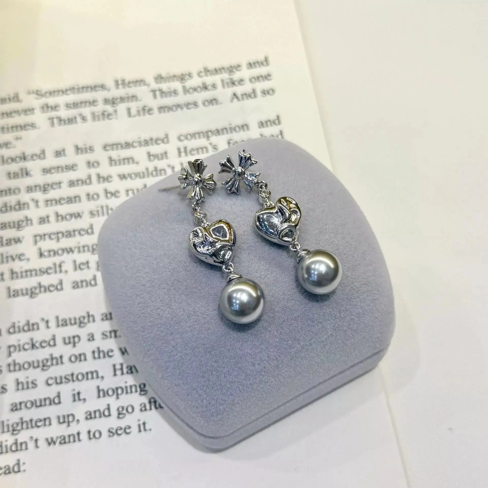 Woman wearing pearl heart drop earrings