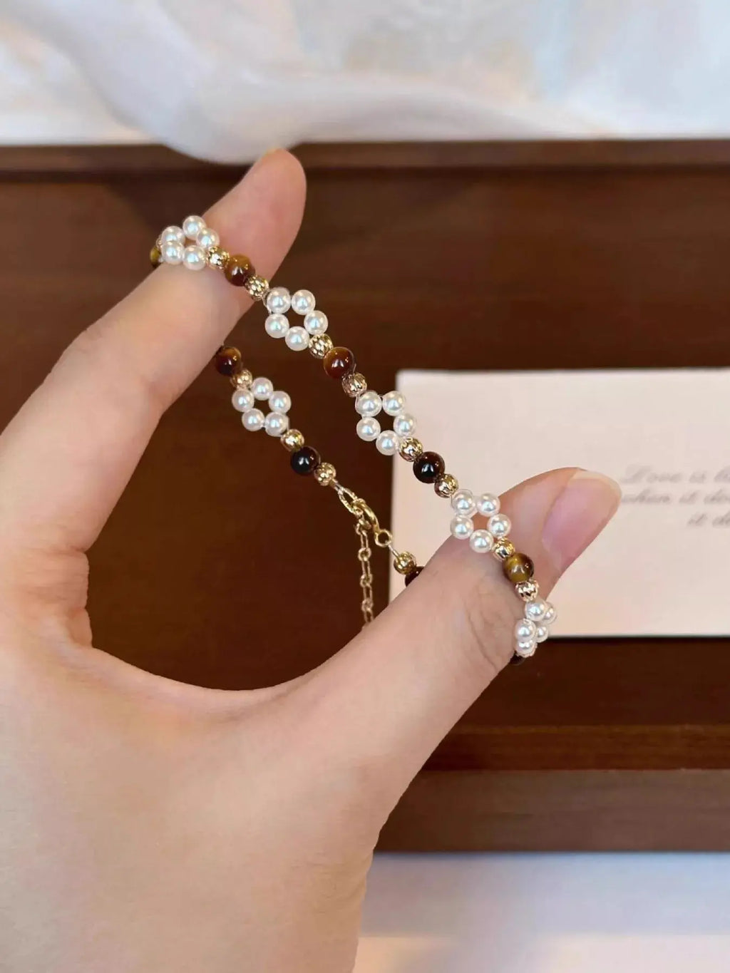 Woman wearing pearl and tiger eye beaded bracelet
