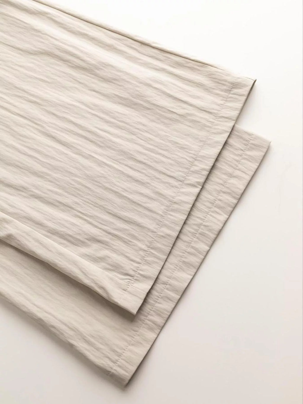 Two beige fabric swatches on a light pink background Vicsxox.com