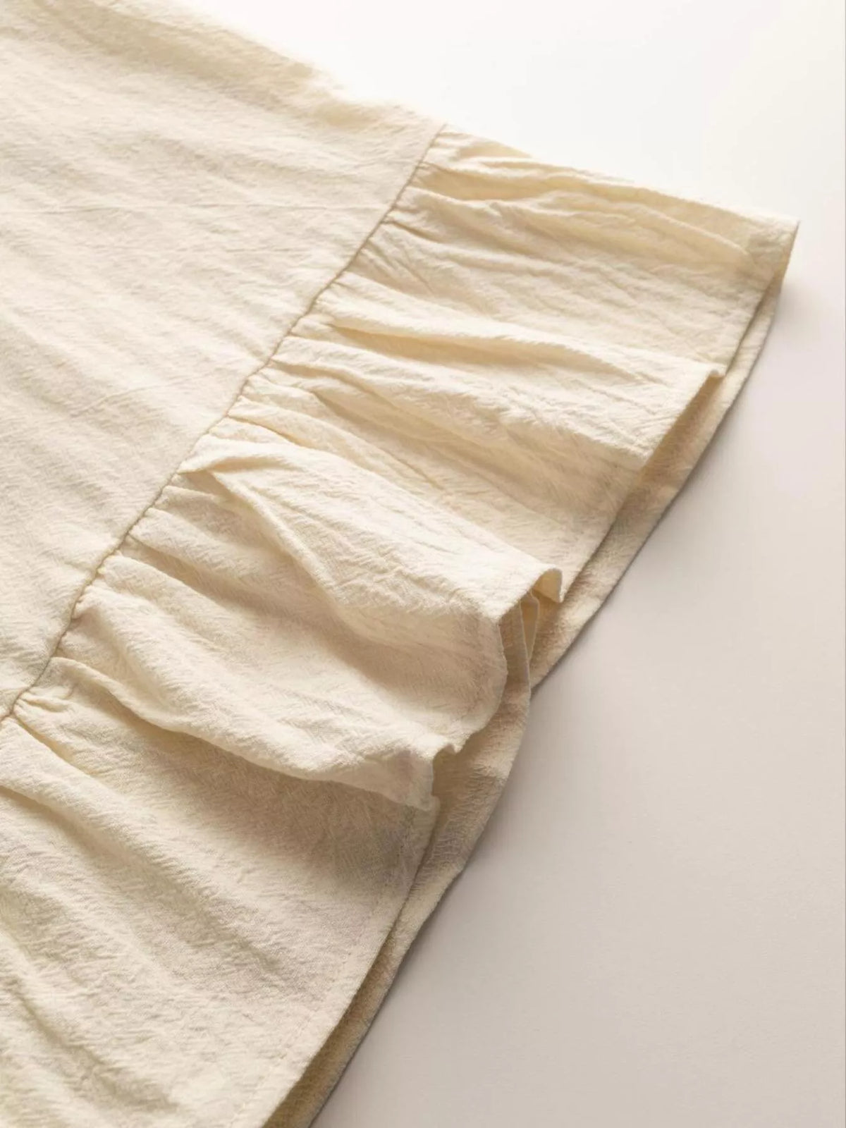 Close-up of beige fabric with a subtle pattern on a light background Vicsxox.com