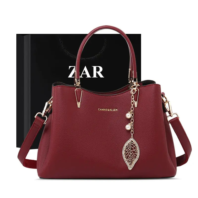 Structured vegan leather top-handle handbag with leaf charm, front view Vicsxox.com