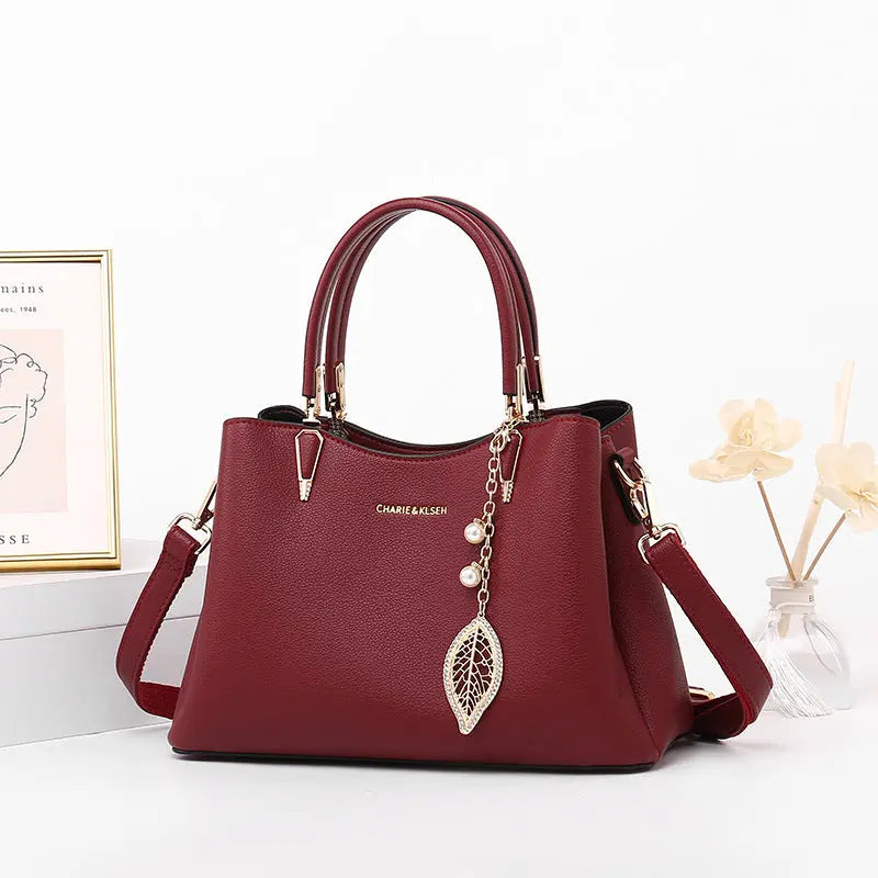 Structured vegan leather top-handle handbag with leaf charm, front view Vicsxox.com