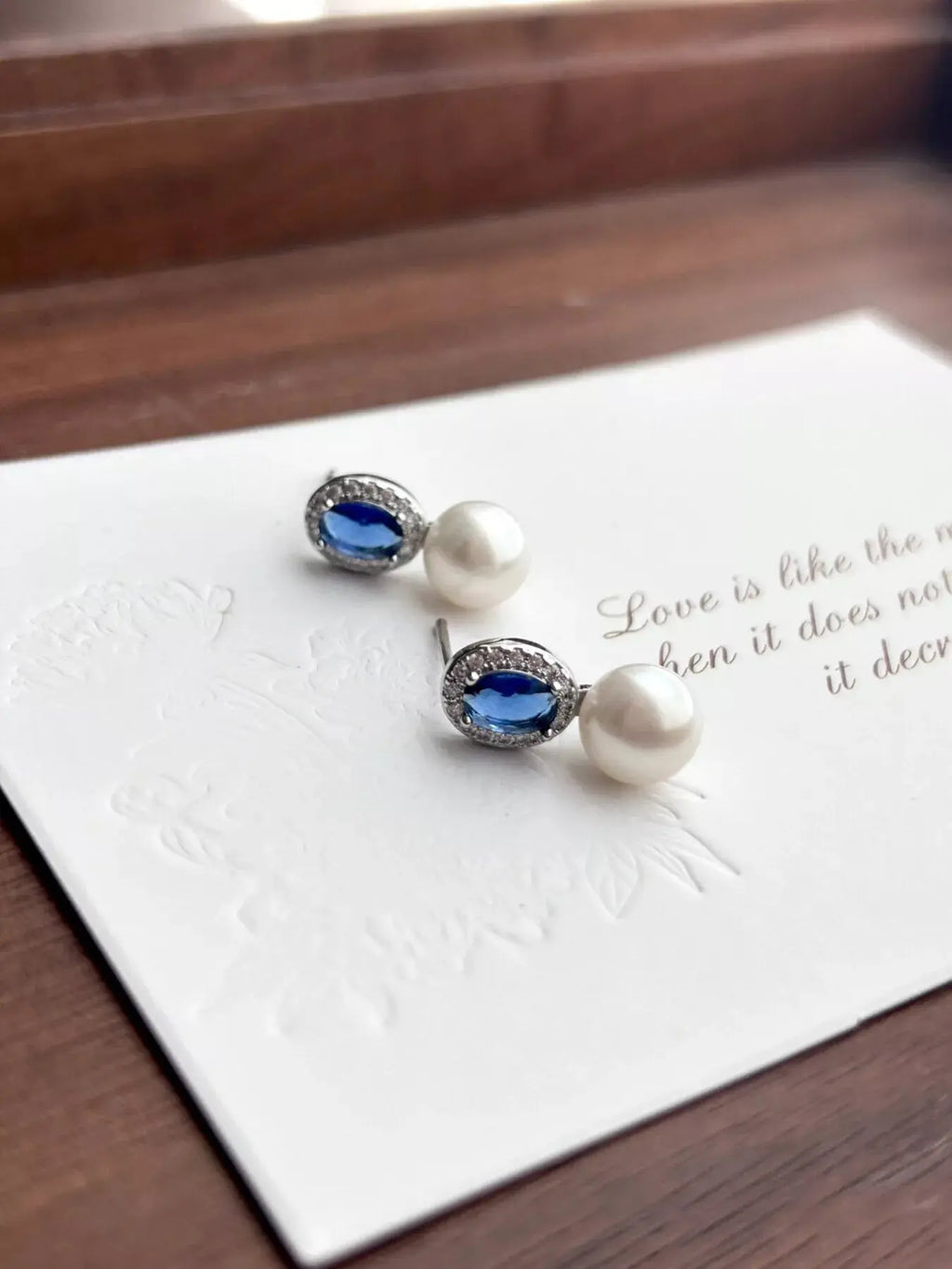 Close-up of crystal and zircon detail on pearl drop earrings