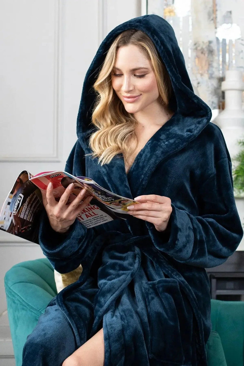 Woman in a navy blue robe reading a magazine indoors. Vicsxox.com