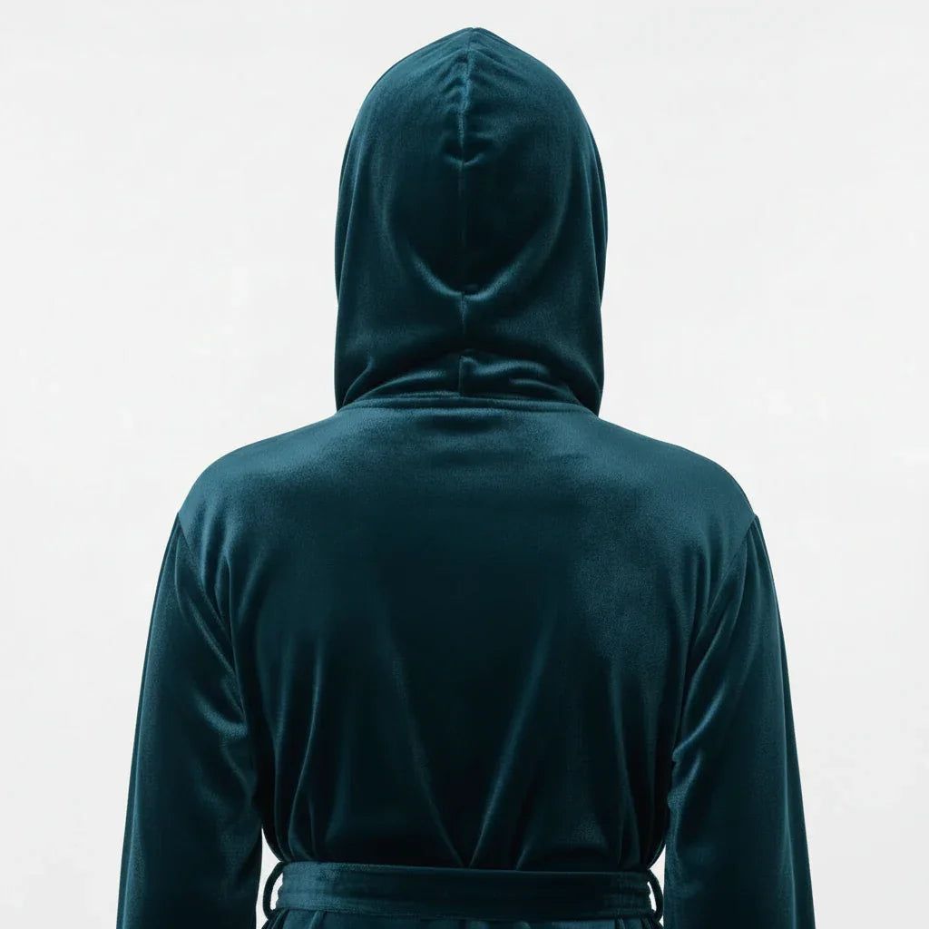 Person wearing a dark green hooded garment on a light gray background. Vicsxox.com