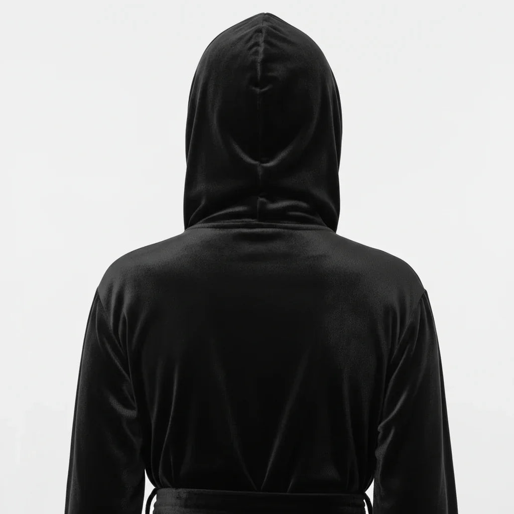 Person wearing a black hooded outfit on a white background. Vicsxox.com