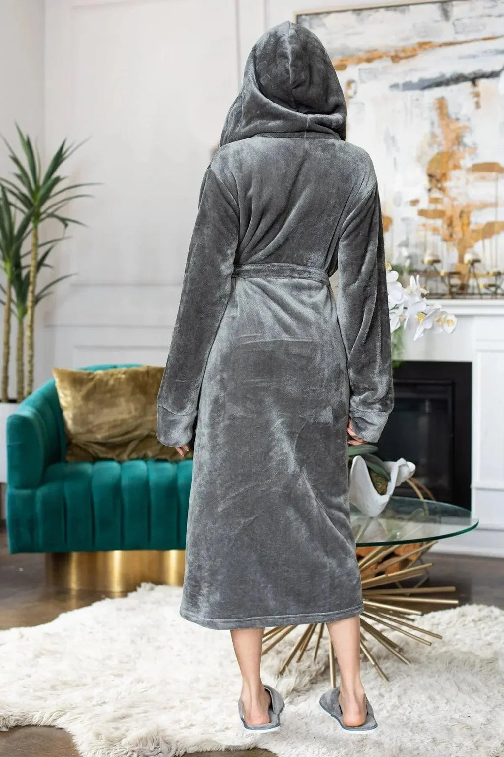 Person wearing a gray hooded robe in a living room setting. Vicsxox.com